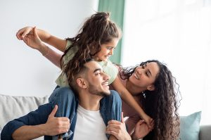Parents smiling and playing with daughter