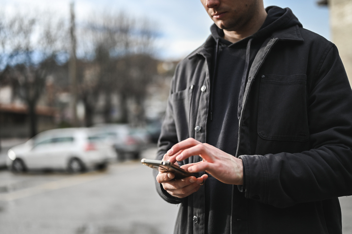 Person in jacket holding a mobile phone